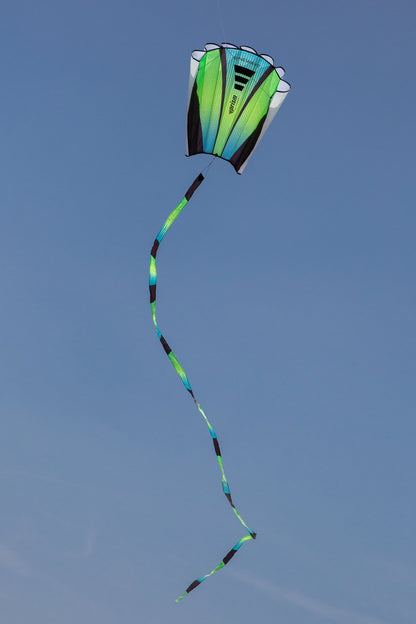 The Aurora Sinewave (blue, yellow and green) in flight with a cloudless blue sky in the background.